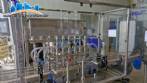 Complete filling line with Tecman Nelpas Tecnoenvase Tudela bottle filling, labeling, capping, and positioning machines for cosmetic liquids.